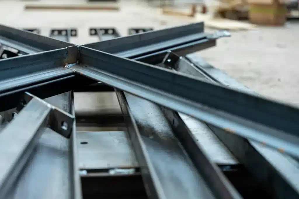 Ferrailleur récupérant des poutres métalliques prêtes pour le recyclage et la valorisation des métaux ferreux.

