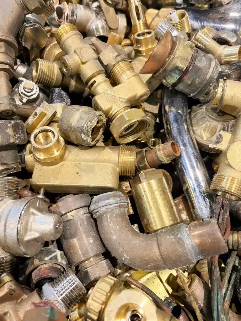 Tas de pièces de plomberie en cuivre et laiton collectées par un ferrailleur pour le recyclage des métaux non ferreux. ​​