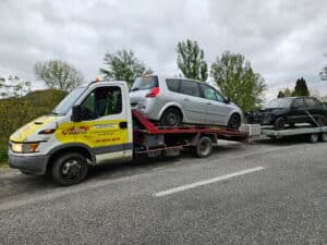 Dépanneuse RONDOT Jean avec un Renault Scénic sur plateau et une épave remorquée. Téléphone : 06 45 05 40 56.